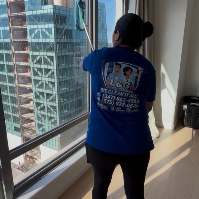 Cleaning floor-to-ceiling windows in a high-rise apartment